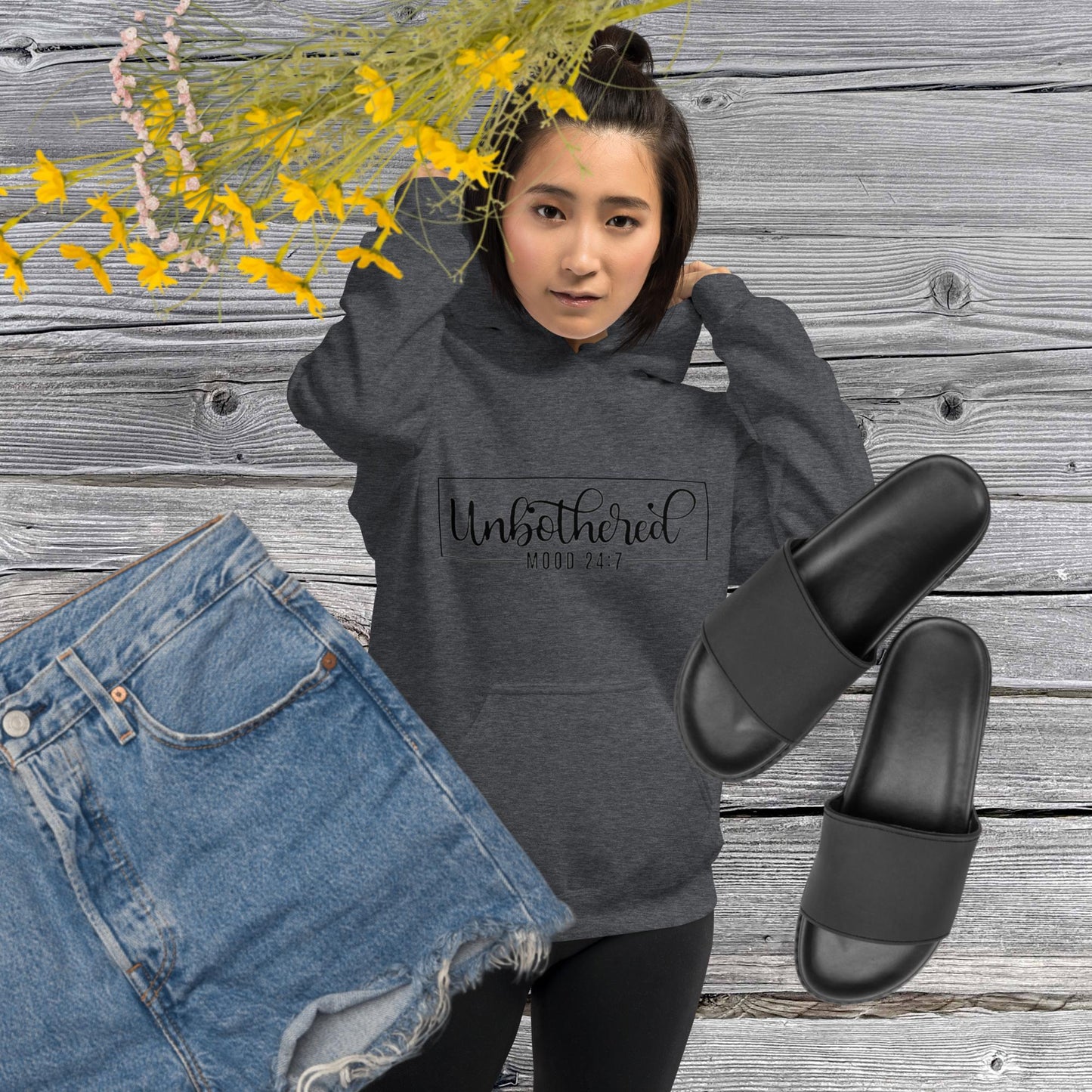 Dark heather colored unisex hoodie featuring the word 'Unbothered,' serving as a reminder not to stress over things outside of your control.