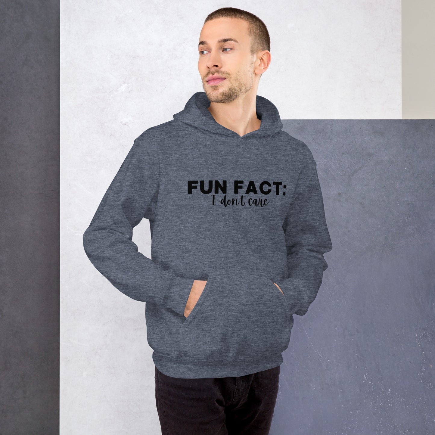 Heather sport dark navy colored unisex hoodie featuring the phrase 'Fun Fact: I Don't Care' in bold black writing on the front above the front pouch pocket