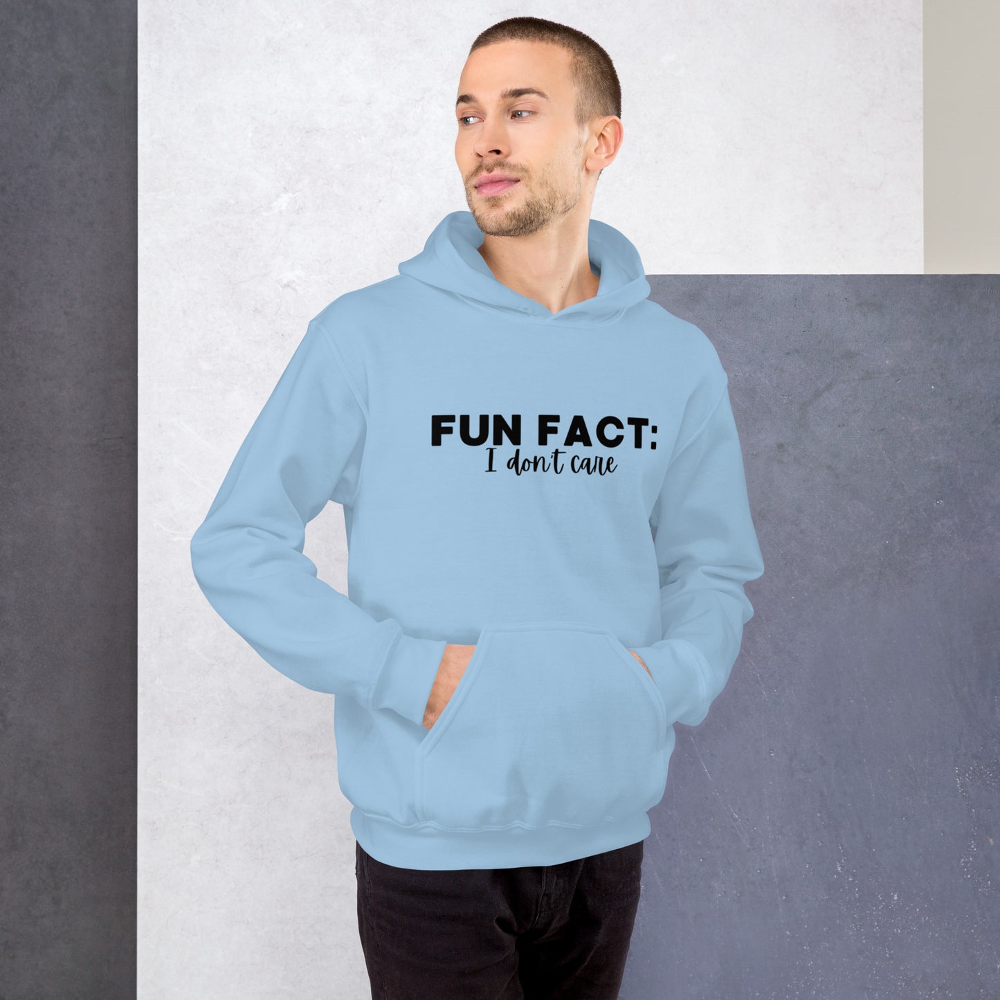 Light blue colored unisex hoodie featuring the phrase 'Fun Fact: I Don't Care' in bold black writing on the front above the front pouch pocket