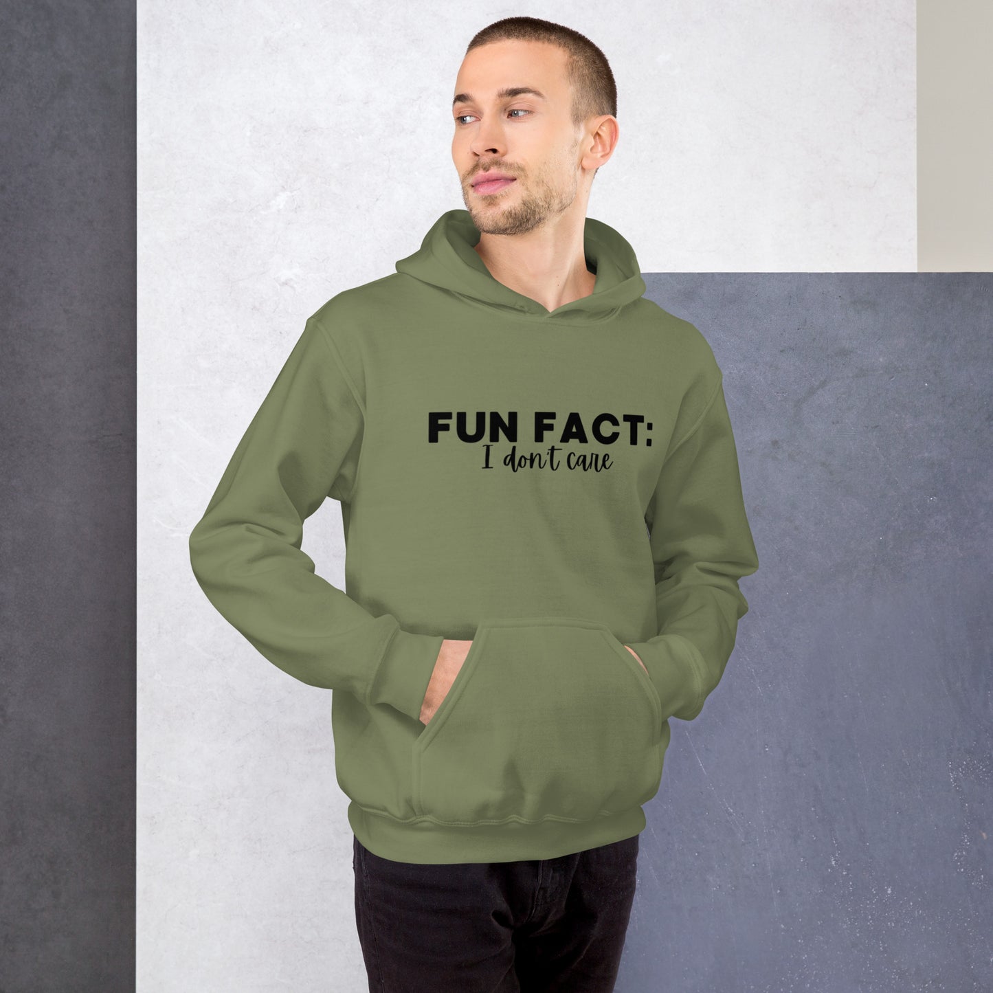 Military green colored unisex hoodie featuring the phrase 'Fun Fact: I Don't Care' in bold black writing on the front above the front pouch pocket