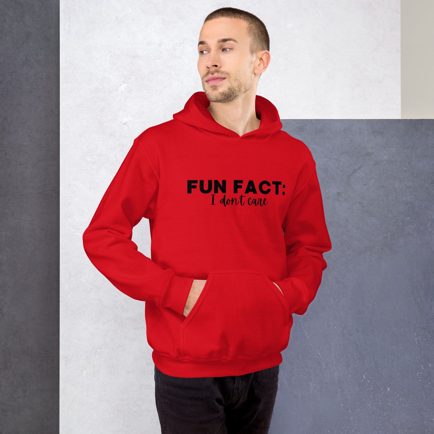 Red unisex hoodie featuring the phrase 'Fun Fact: I Don't Care' in bold black writing on the front above the front pouch pocket