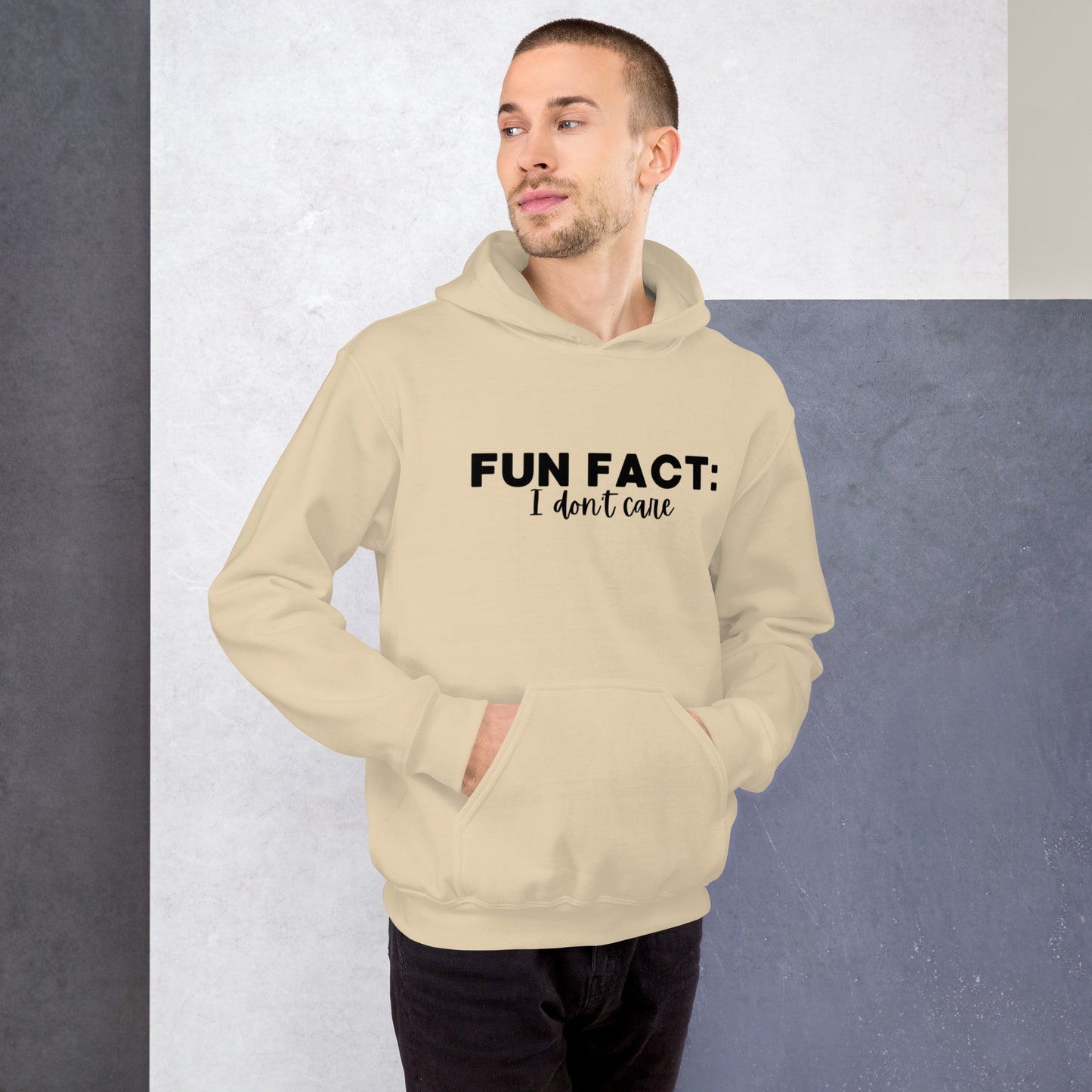 Sand colored unisex hoodie featuring the phrase 'Fun Fact: I Don't Care' in bold black writing on the front above the front pouch pocket