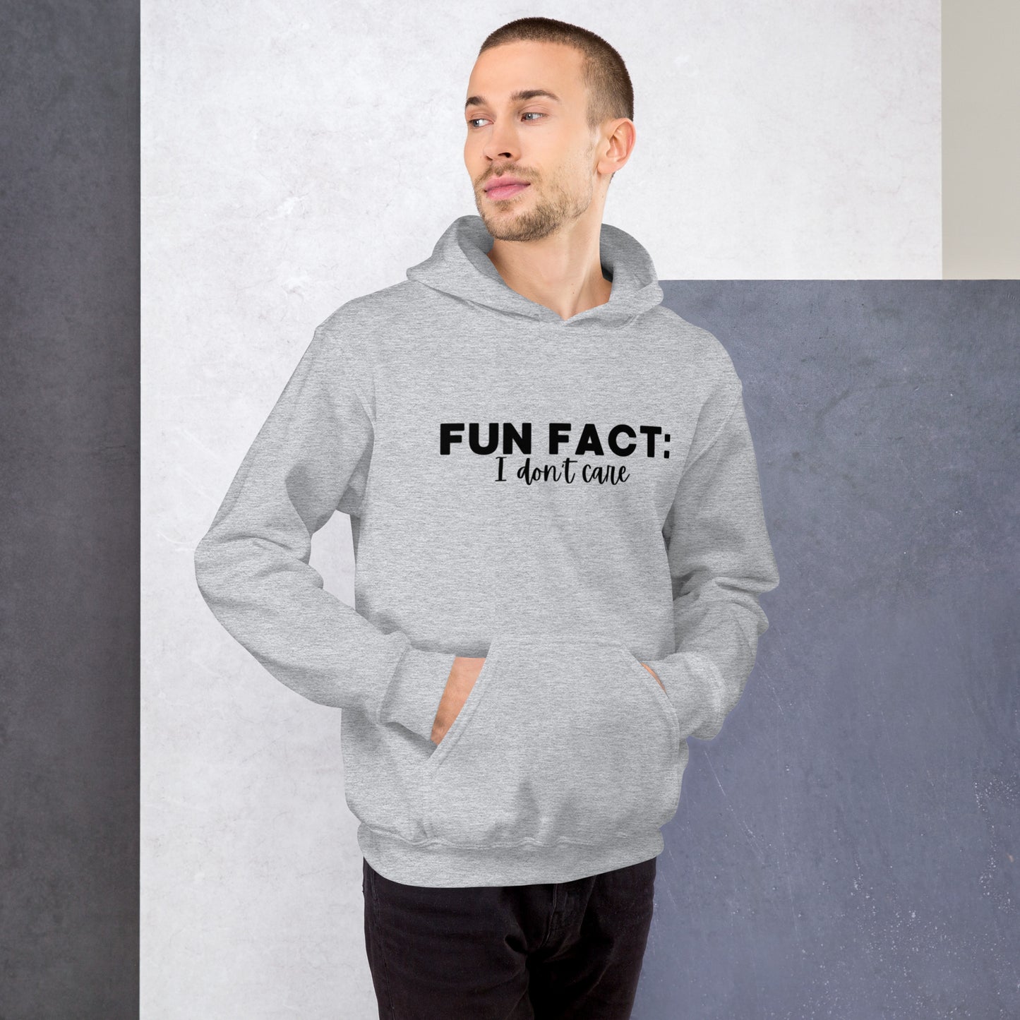 Sport grey colored unisex hoodie featuring the phrase 'Fun Fact: I Don't Care' in bold black writing on the front above the front pouch pocket