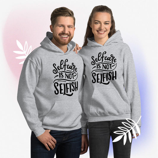 Sport grey colored unisex hoodie featuring the phrase 'Selfcare is NOT Selfish' in bold black text. This hoodie emphasizes that self-care should be a priority for everyone.