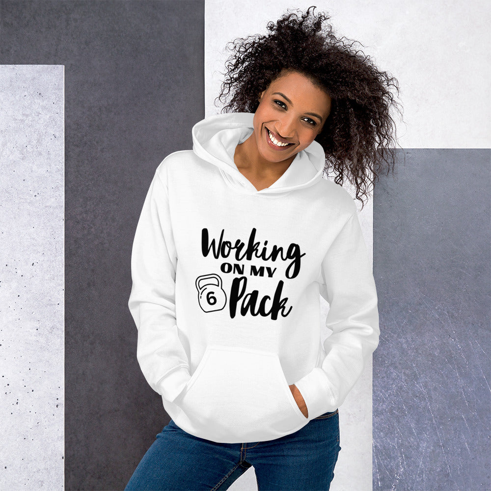 White unisex hoodie featuring the phrase 'Working on my 6 Pack' in black font. This cozy hoodie is perfect for the gym or evening walks.